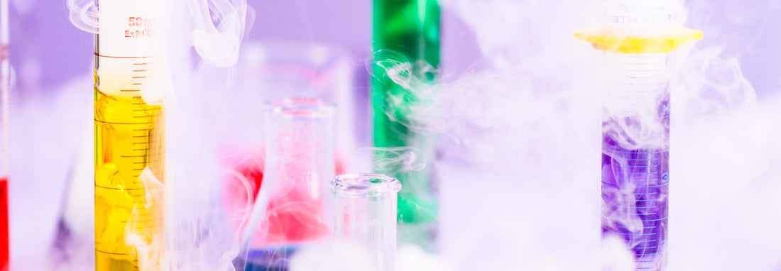 colored liquids in test tubes and beakers, surrounded by vapors from dry ice